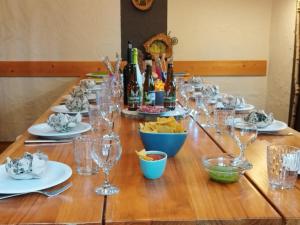 uma longa mesa com copos de vinho e garrafas de vinho em La Babillarde em Auby-sur-Semois