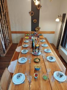 a long wooden table with plates and wine glasses at La Babillarde in Auby-sur-Semois