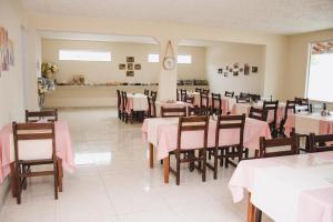 a restaurant with tables and chairs with pink tablecloths at CALDAS PALACE HOTEL JORRO in Tucano