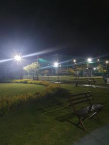 a park bench in a park at night with lights at Muro Alto condomínio CLUBE AP 411 in Porto De Galinhas