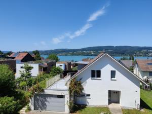 a white house on a hill with houses at Bed & Breakfast Lake View in Steckborn