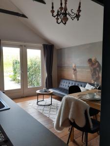 uma sala de estar com um sofá e uma mesa em Gastenverblijf By ús thús em Anjum