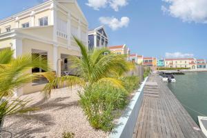 a building next to a body of water with palm trees at Lagoon Lounge - Waterfront villa with private pool in Kralendijk +43 photos