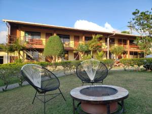 two chairs and a table in front of a building at El Nido Lodge in Monteverde Costa Rica