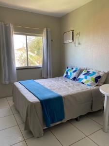 een slaapkamer met een groot bed en een raam bij Flat Praia da Taíba - com vista Mar in Taíba