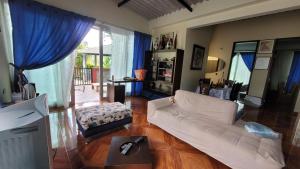 a living room with a white couch and blue curtains at Hospedaje RM in Villeta