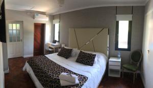 a bedroom with a large bed and a green chair at Like at Home Ezeiza in Ezeiza