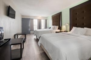ブライズビルにあるAmericas Best Value Inn and Suites Blytheville by Sonestaのベッド2台と薄型テレビ付きのホテルの部屋