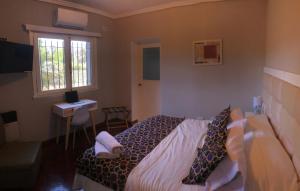 a bedroom with a bed and a desk and a window at Like at Home Ezeiza in Ezeiza