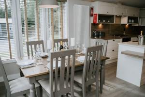 a kitchen with a wooden table with chairs and a dining room at Casa Di Lusso Luxury lodge in Woodhall Spa