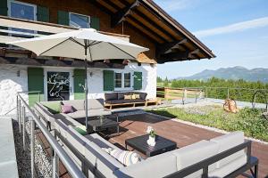 a patio with a table and an umbrella at Elchegg - Chalet & Panorama-Loft in Rettenberg