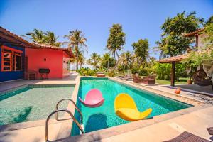uma piscina com cadeiras numa casa em Pousada Villa Tainá Bahia em Arraial d'Ajuda