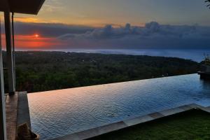 a view of the ocean from a house with a swimming pool at Uluwatu Sunset Hills in Uluwatu