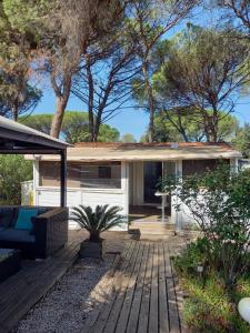 a house with a wooden deck in the yard at Mobilhome 6personnes camping oasis village 5 etoiles in Puget-sur-Argens