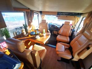 uma vista interior de uma caravana com uma mesa e cadeiras em Rent a BlueClassics 's Campervan AUTOSTAR in Algarve au Portugal em Portimão
