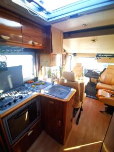 uma cozinha num trailer com um fogão em Rent a BlueClassics 's Campervan AUTOSTAR in Algarve au Portugal em Portimão