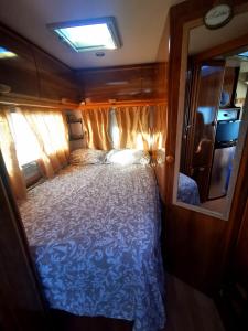 un grande letto nel mezzo di una piccola stanza di Rent a BlueClassics 's Campervan AUTOSTAR in Algarve au Portugal a Portimão