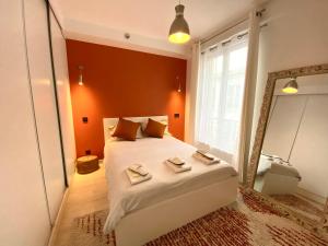 a bedroom with a large bed and a mirror at Le Voltaire apartment - Paris Center in Paris