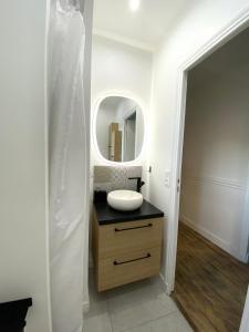 a bathroom with a sink and a mirror at Le Voltaire apartment - Paris Center in Paris