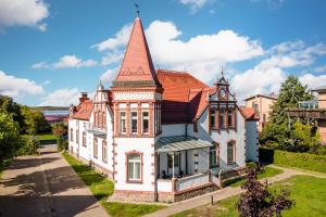 an old house with a turret on a street at Hotel Villa am Stadthafen in Neustrelitz