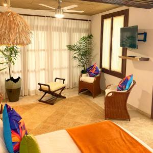 - un salon avec un canapé, des chaises et une télévision dans l'établissement Muúnek Hotel Boutique Art & Spa, à Barra Vieja