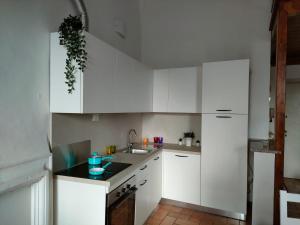 a white kitchen with white cabinets and a sink at Il cielo di Raffaello in Urbino