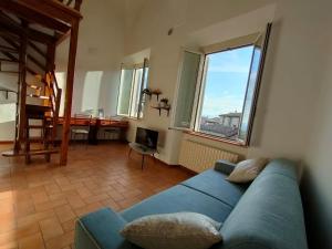 a living room with a blue couch and some windows at Il cielo di Raffaello in Urbino