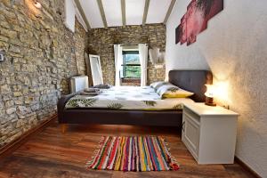 sypialnia z łóżkiem i kamienną ścianą w obiekcie Villa Luna w mieście Motovun