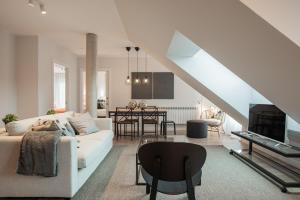 a living room with a white couch and a dining room at El Prau de Mito in Cangas de Onís