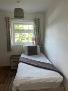 Bett in einem Schlafzimmer mit Fenster in der Unterkunft Cosy Apartment in Wetheral,Cumbria in Wetheral