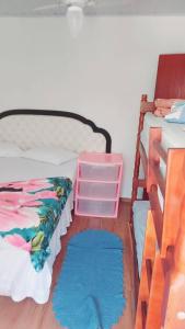 a bedroom with a bed and a ladder and two rugs at Casas de Aluguel da Lulu in Itapema