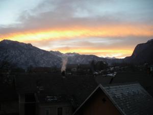 a sunset over a city with mountains in the background at Apartment Cesar in Bohinj