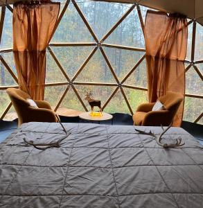 Cette chambre dispose d'une grande fenêtre avec un lit et des chaises. dans l'établissement Pandomes Aurora Igloo Hotel, à Rovaniemi