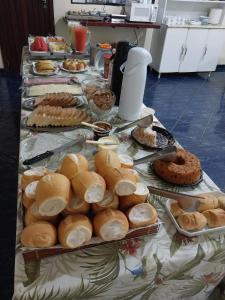 a table topped with plates of bread and pastries at Dominique Hotel in Ouro Preto dʼOeste