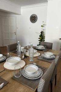 een houten tafel met borden en borden erop bij Stylish 3 BR apartment in Kyrenia Northern Cyprus in Kyrenia