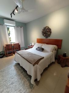 a bedroom with a large bed with a wooden headboard at Casa da Lu Itacoatiara -Suite Alto Mourão in Niterói