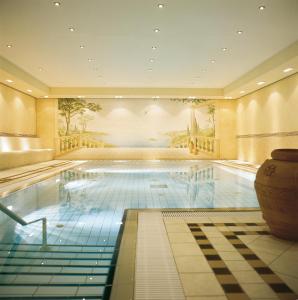 a pool in a hotel with a painting on the wall at Seeresidenz Alte Post in Seeshaupt