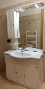 uma casa de banho com um lavatório branco e um espelho. em A Casa di Franco em Milazzo