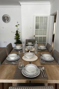 una mesa de madera con platos y platos. en Stylish 3 BR apartment in Kyrenia Northern Cyprus, en Kyrenia