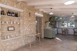 una cocina con una pared de piedra con estanterías y una mesa en Giallo Ficodindia, en Canicattì