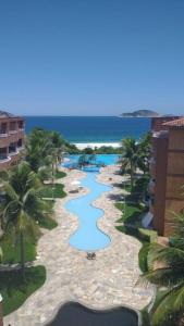 uma vista aérea de uma piscina de resort com palmeiras em Apto Pé na Areia Condomínio Oceanside Camboinhas em Niterói