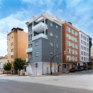 un edificio alto gris en una calle de la ciudad en AAC Málaga - Apartamento muy cómodo y bien comunicado, a 1,3km del centro en Málaga