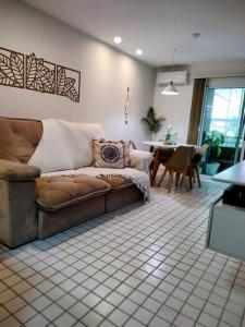 uma sala de estar com um sofá e uma mesa em Apto Pé na Areia Condomínio Oceanside Camboinhas em Niterói