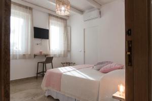 Un dormitorio con una cama con almohadas rosas. en Giallo Ficodindia, en Canicattì