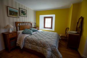 Schlafzimmer mit einem Bett und einem Fenster in der Unterkunft Casa Tiquio Montaña Palentina in Rabanal de los Caballeros