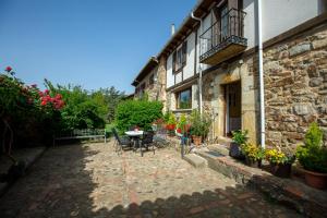 eine Terrasse außerhalb eines Gebäudes mit einem Tisch und Stühlen in der Unterkunft Casa Tiquio Montaña Palentina in Rabanal de los Caballeros