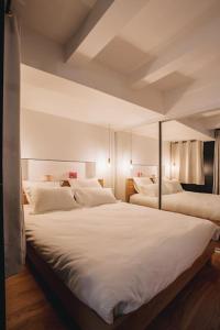a bedroom with two beds with white sheets at La Vie en Rose - Luxe, calme & hypercentre - 3* in Annecy