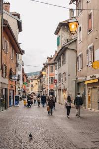 a group of people walking down a street at La Vie en Rose - Luxe, calme & hypercentre - 3* in Annecy