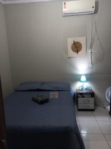 Studio Próximo ao centro في بالماس: غرفة نوم مع سرير مع قبعة عليه
