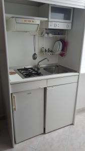 a small kitchen with a sink and a stove at Residence Anna in Paestum